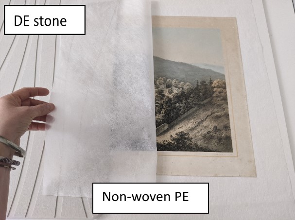 Fig. 3 – A lithograph is dried between two DE stones with an isolating layer of non-woven polyester fabric. Photography by Ewa Paul.